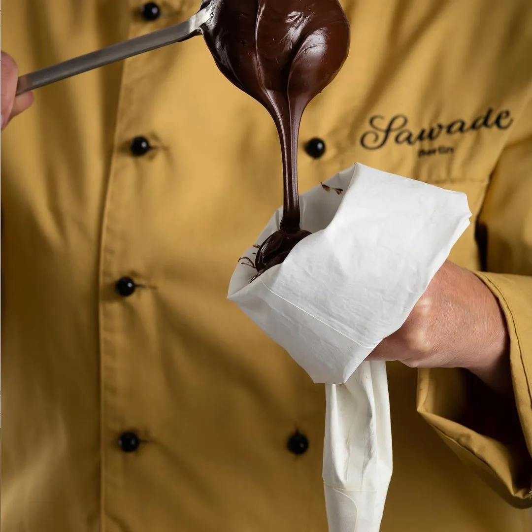 Flüssige Schokolade wird in einer Spitztüte gefüllt