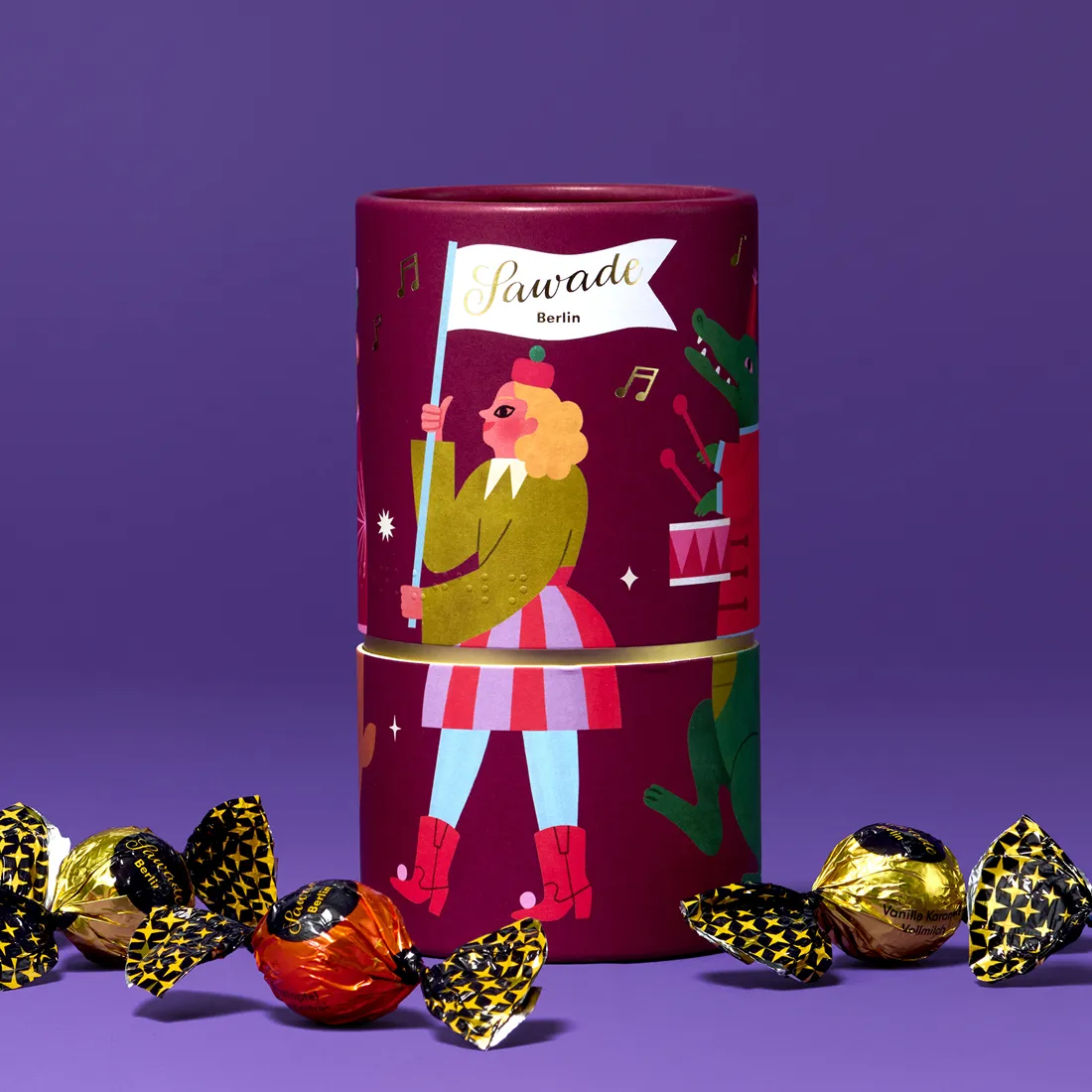 Stimmungsbild: Geschenkdose Parade mit einzelnen Pralinenkugeln vor lila Hintergrund