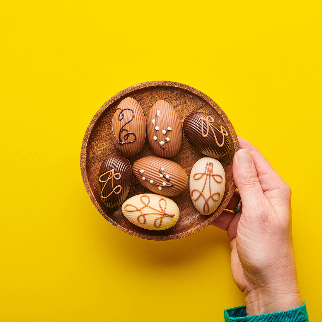Stimmungsbild: Mensch hält verschiedene Sorten Desserteier dekorativ in einer Schale Stimmungsbild: Mensch hält verschiedene Sorten Desserteier dekorativ in einer Schale