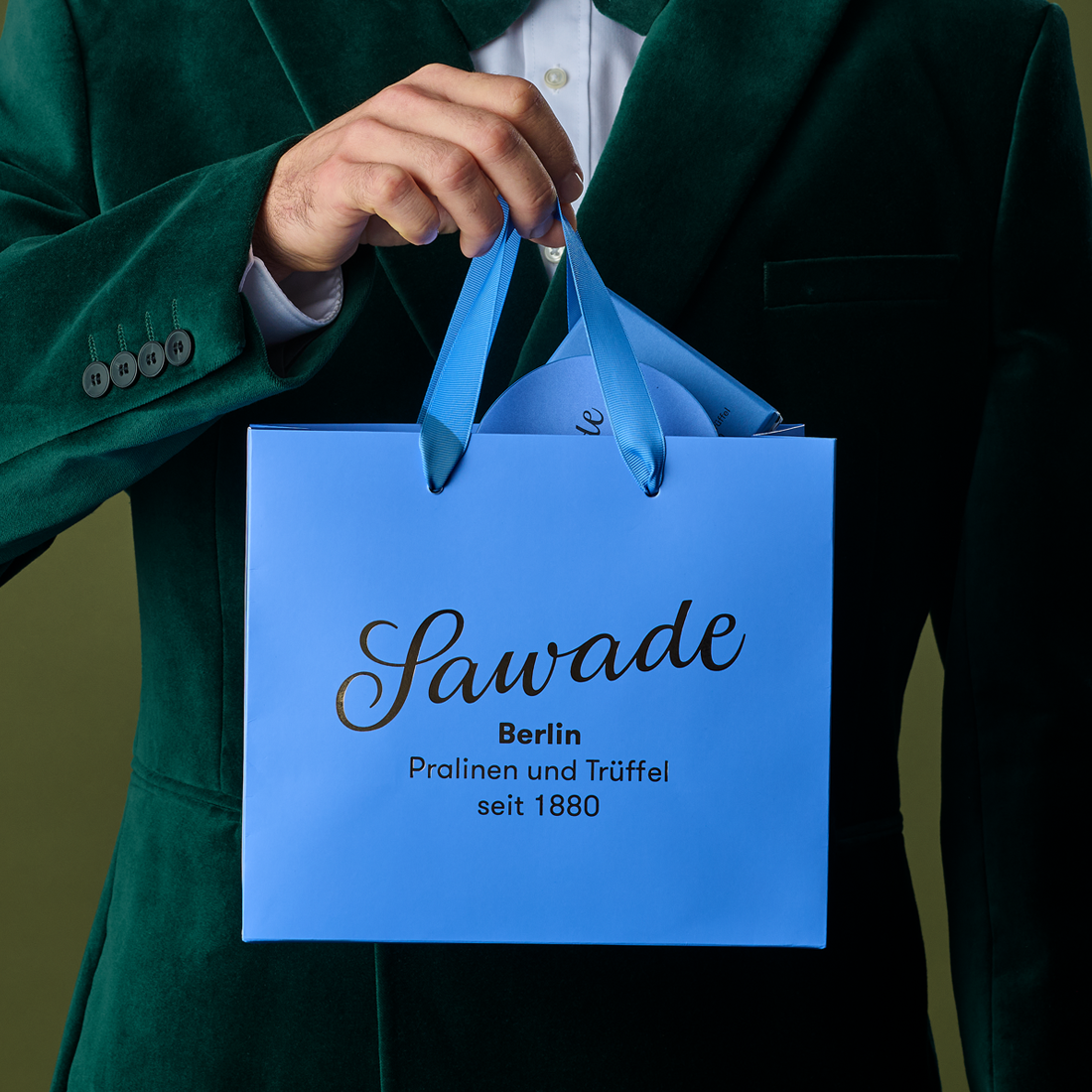 Mann hält Geschenktüte Blau