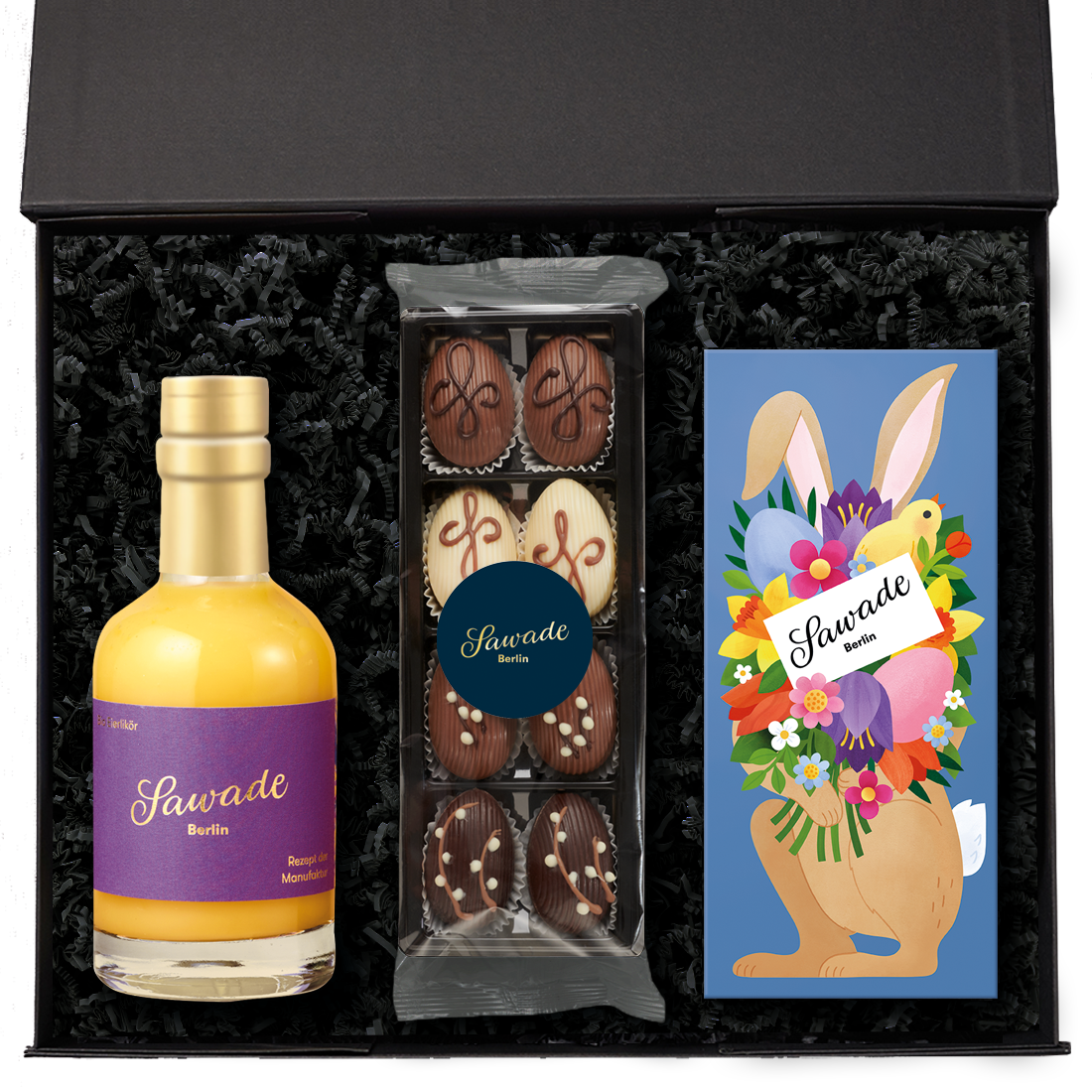 Geschenkbox »Ei, Ei, Ei« Geschenkbox offen mit einer Flasche Eierlikör, Dessert Eier und einer Pralinenschachtel Osterhase