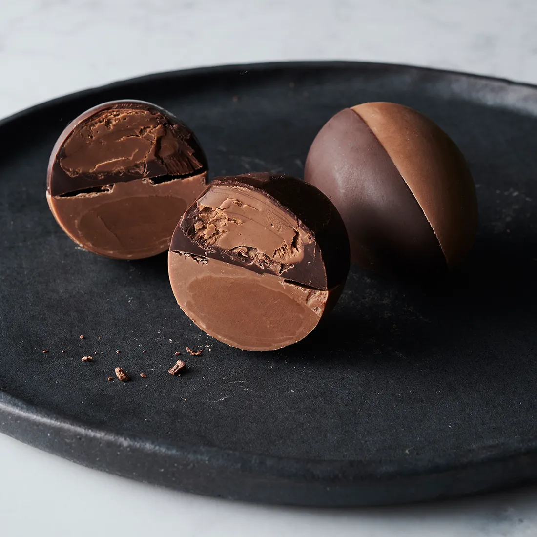 Nussnougat Ei Halb / Halb, 60g Stimmungsbild: Nussnougat Dessert Ei dekorativ aufgeschnitten