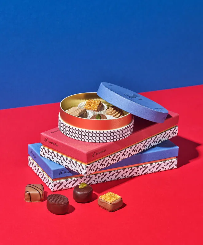 Stimmungsbild: Pralinenschachteln gestapelt und gefüllt mit Pralinen aus Vollmilchschokolade und Zartbitterschokoladeschokolade