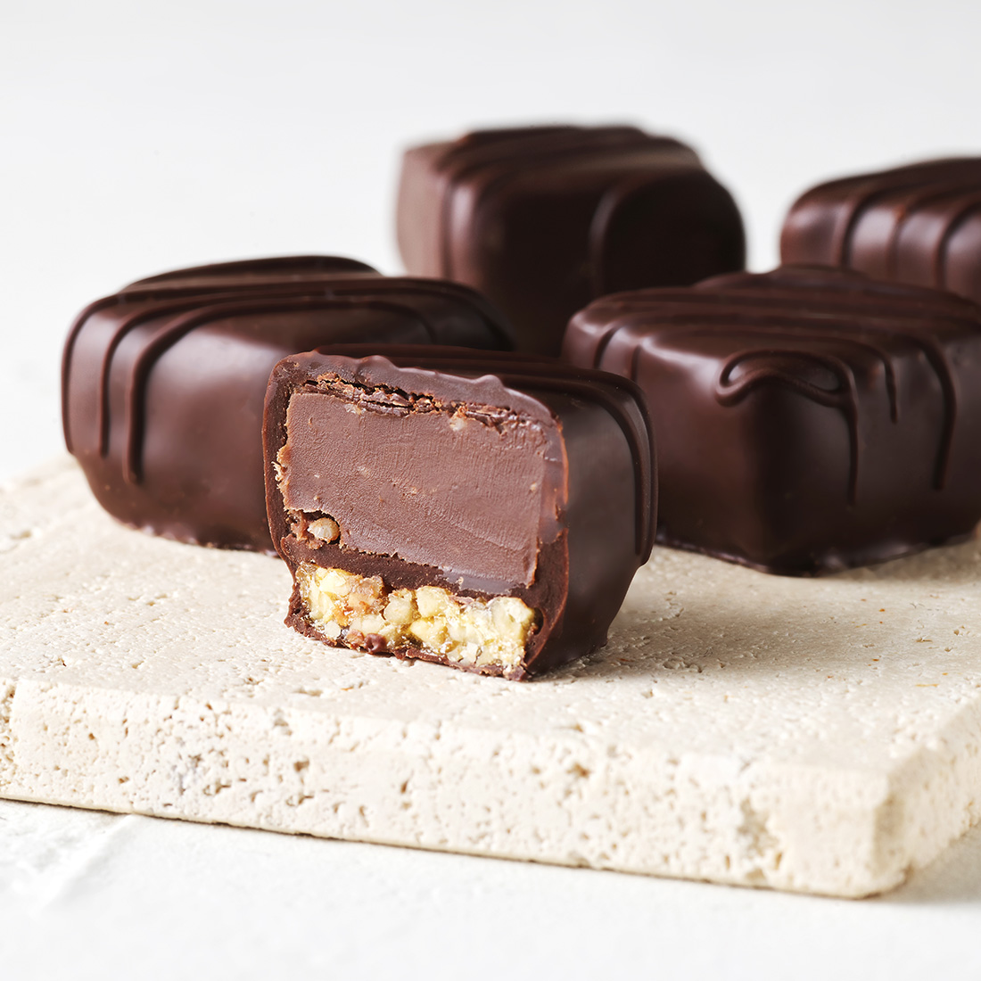 Stimmungsbild: Trüffel-Krokant Praline dekorativ angeschnitten Stimmungsbild: Trüffel-Krokant Praline dekorativ angeschnitten
