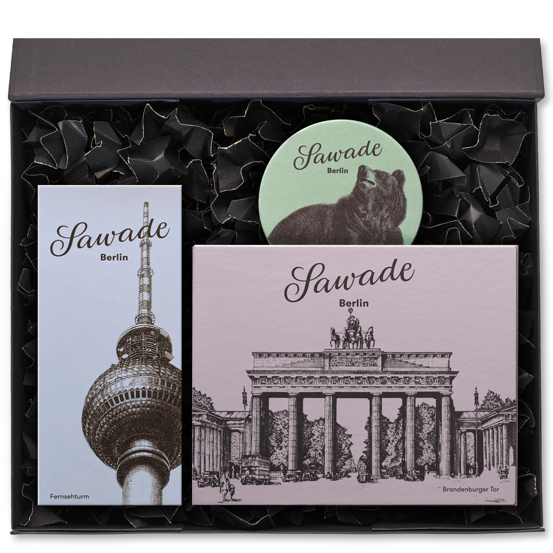 Geschenkbox offen mit einer großen Pralinenschachtel Brandenburger Tor, einer Pralinenschachtel Fernsehturm und einer Runddose Bär