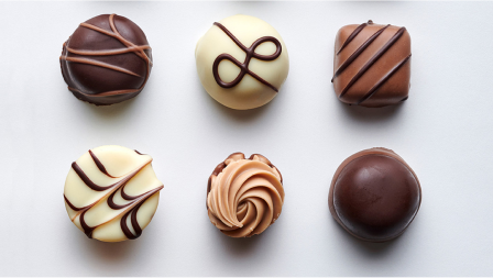 Produktbild: Pralinen mit verschiedenen Schokoladenfarben und Garnituren von oben fotografiert Produktbild: Pralinen mit verschiedenen Schokoladenfarben und Garnituren von oben fotografiert