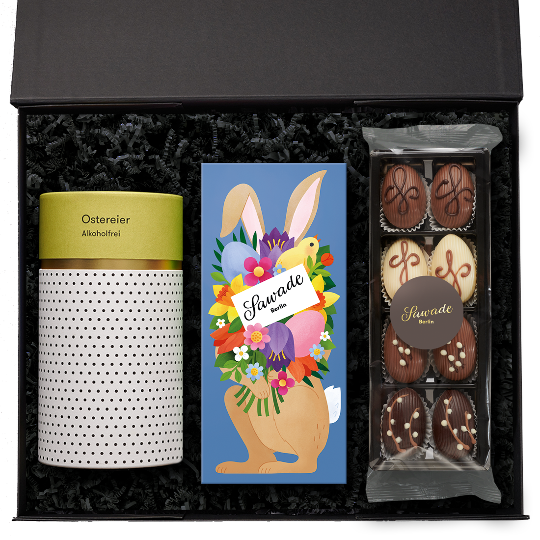 Geschenkbox offen mit einer Pralinenschachtel Osterhase, einer Geschenkdose Ostereier alkoholfrei und einer Dessert Eier Auslese
