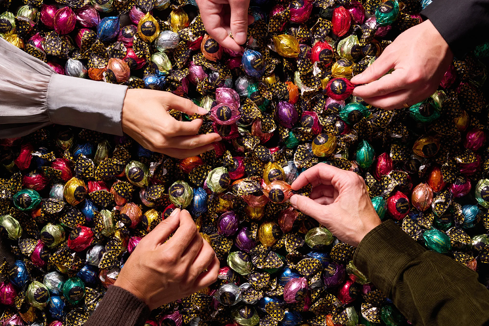 Bild: Hände greifen nach Pralinenkugeln