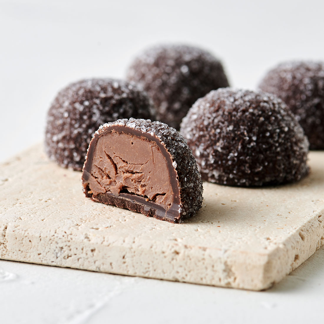Stimmungsbild: Cocnag-Sahne Trüffel Zartbitterschokolade gezuckert dekorativ angeschnitten Stimmungsbild: Cocnag-Sahne Trüffel Zartbitterschokolade gezuckert dekorativ angeschnitten