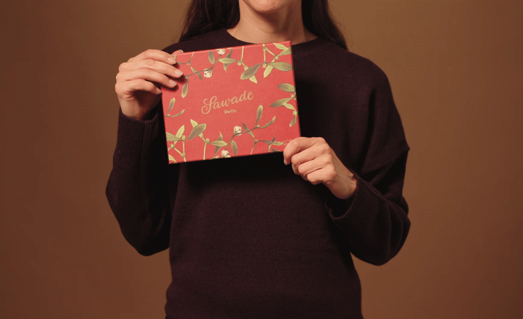 Video: Junge Frau hält eine Pralinenschachtel Mistelzweig, öffnet diese und entnimmt eine Praline