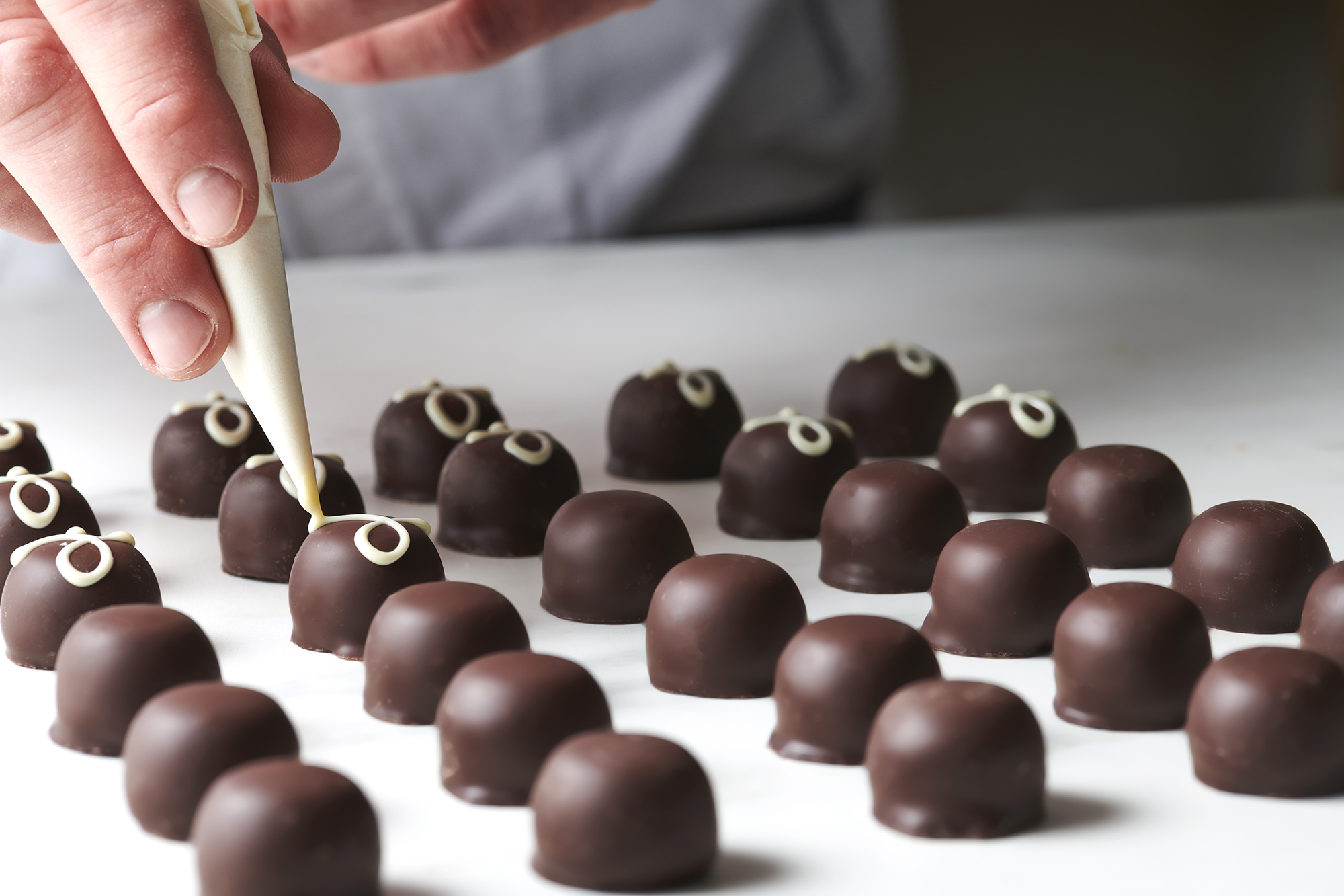 Produktionsbild: garnieren von Mousse au Chocolat Pralinen