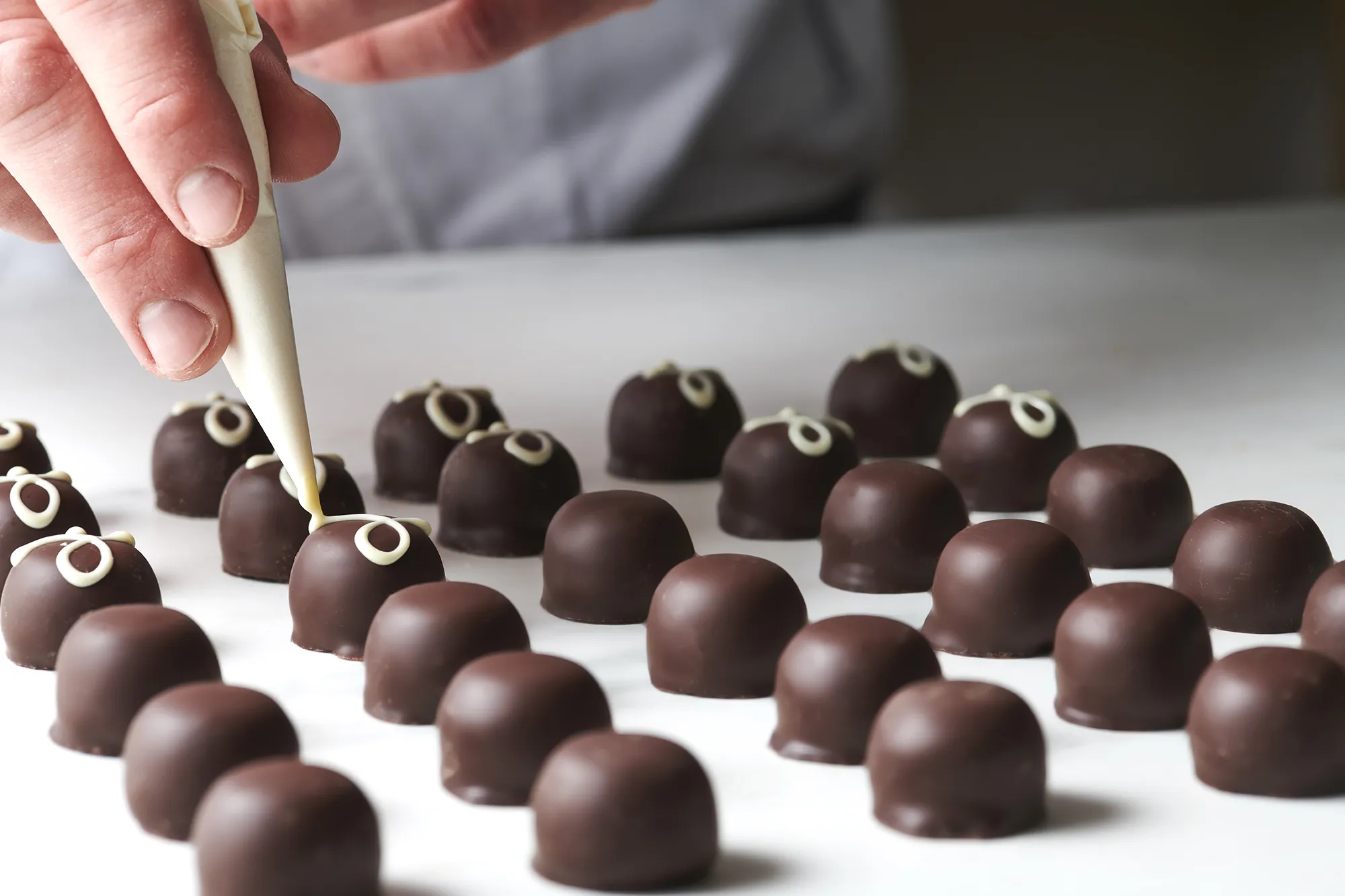 Produktionsbild: garnieren von Mousse au Chocolat Pralinen