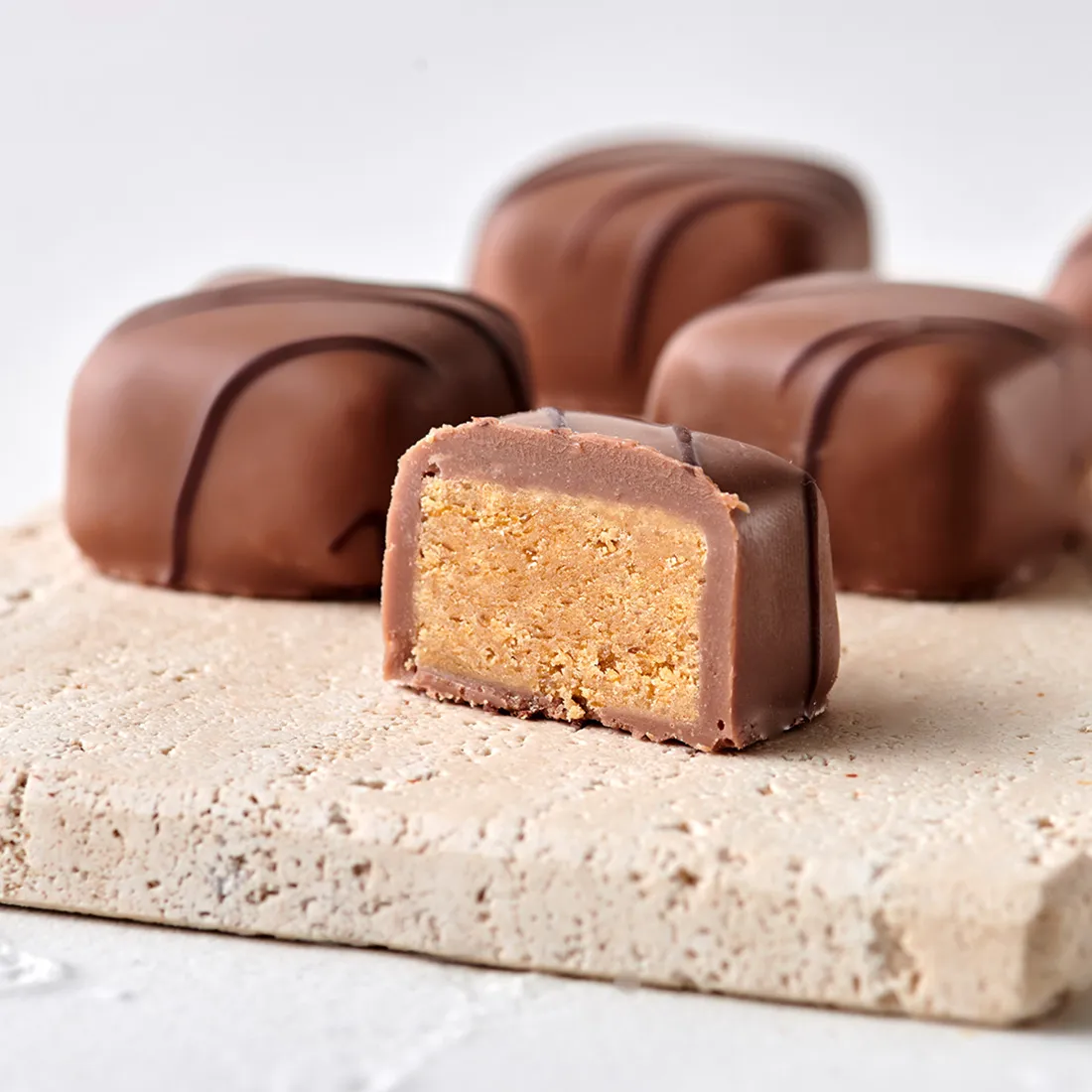 Stimmungsbild: Blätterkrokant in Vollmilchschokolade dekorativ aufgeschnitten