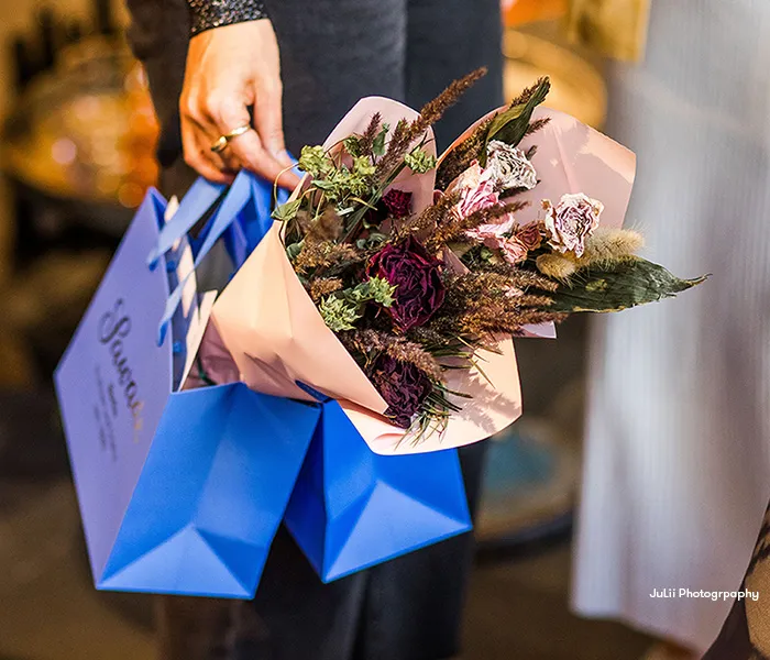 Stimmungsbild: Blumenstrauß in einer kleinen, blauen Sawade Geschenkttüte