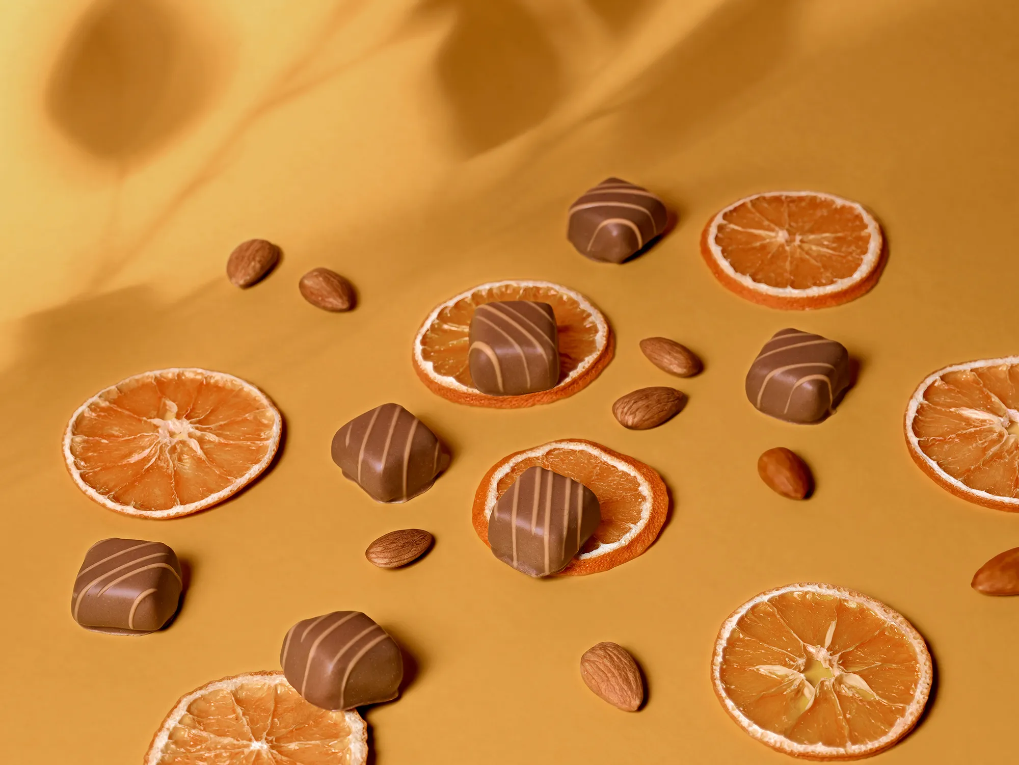 Stimmungsbild: Orange-Marzipan Pralinen mit Orangenscheiben und Mandeln