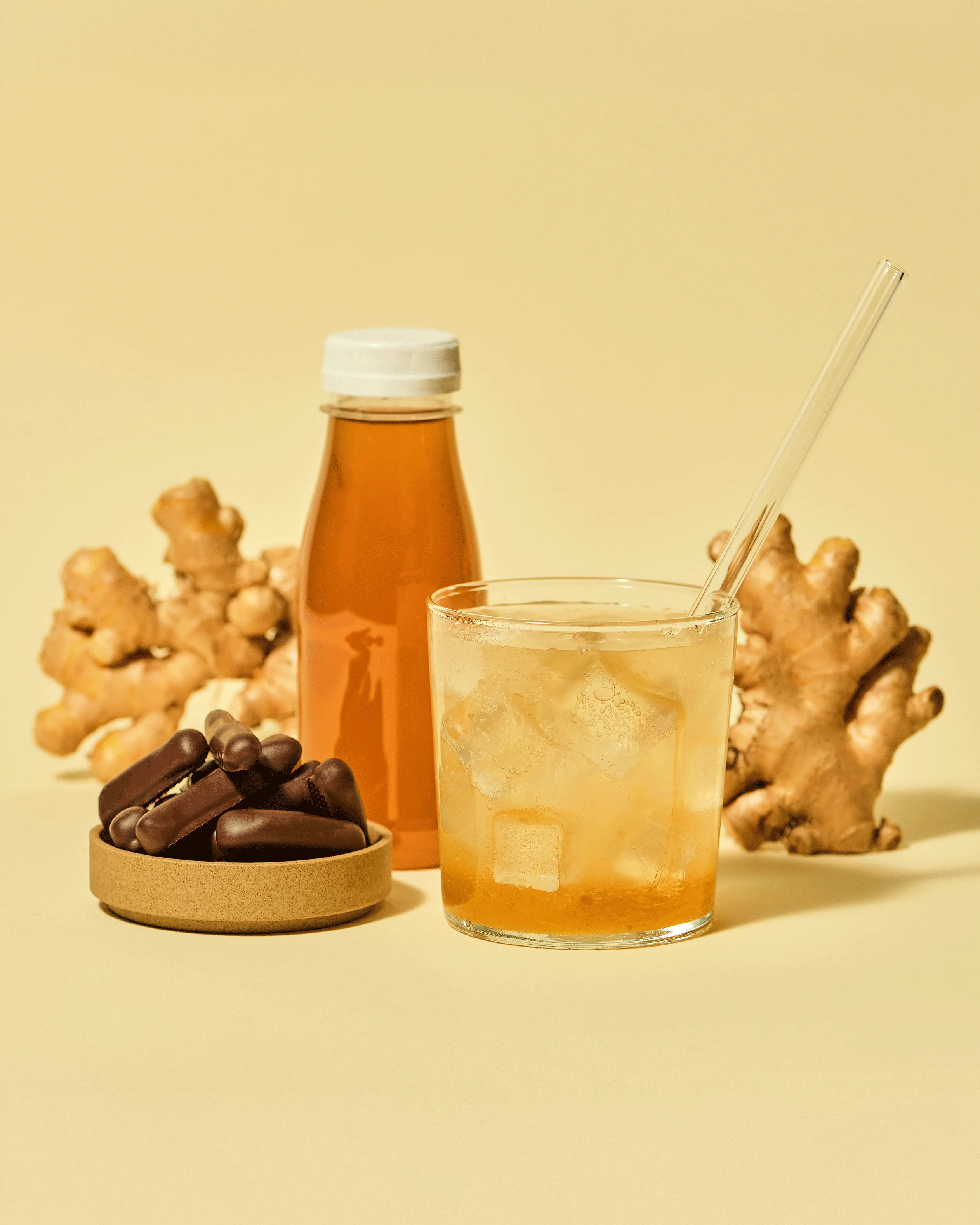 Inszenierung: Flasche Ingwersirup, Ingwer-Stäbchen mit Ingwerwurzel